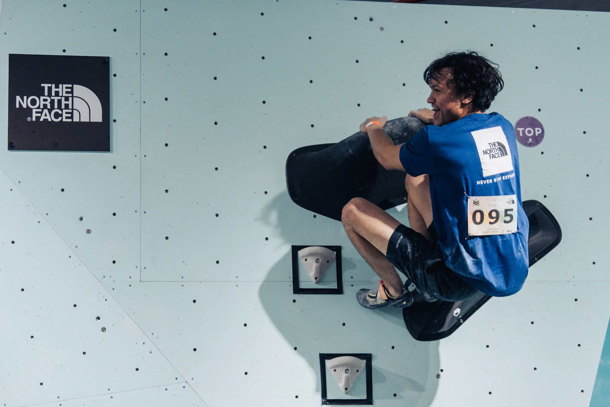 A Squad Games competitor topping a boulder problem