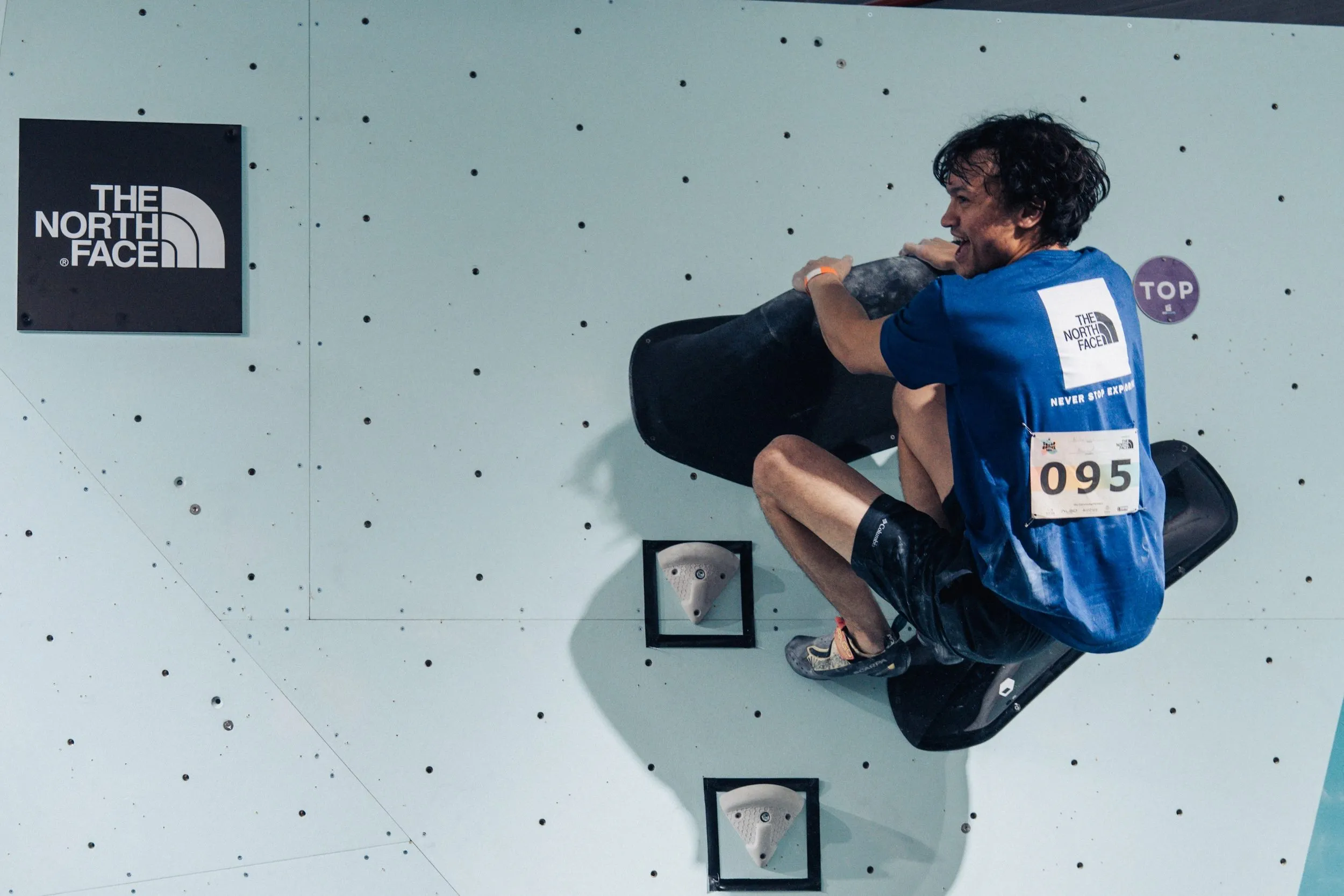 A Squad Games competitor topping a boulder problem