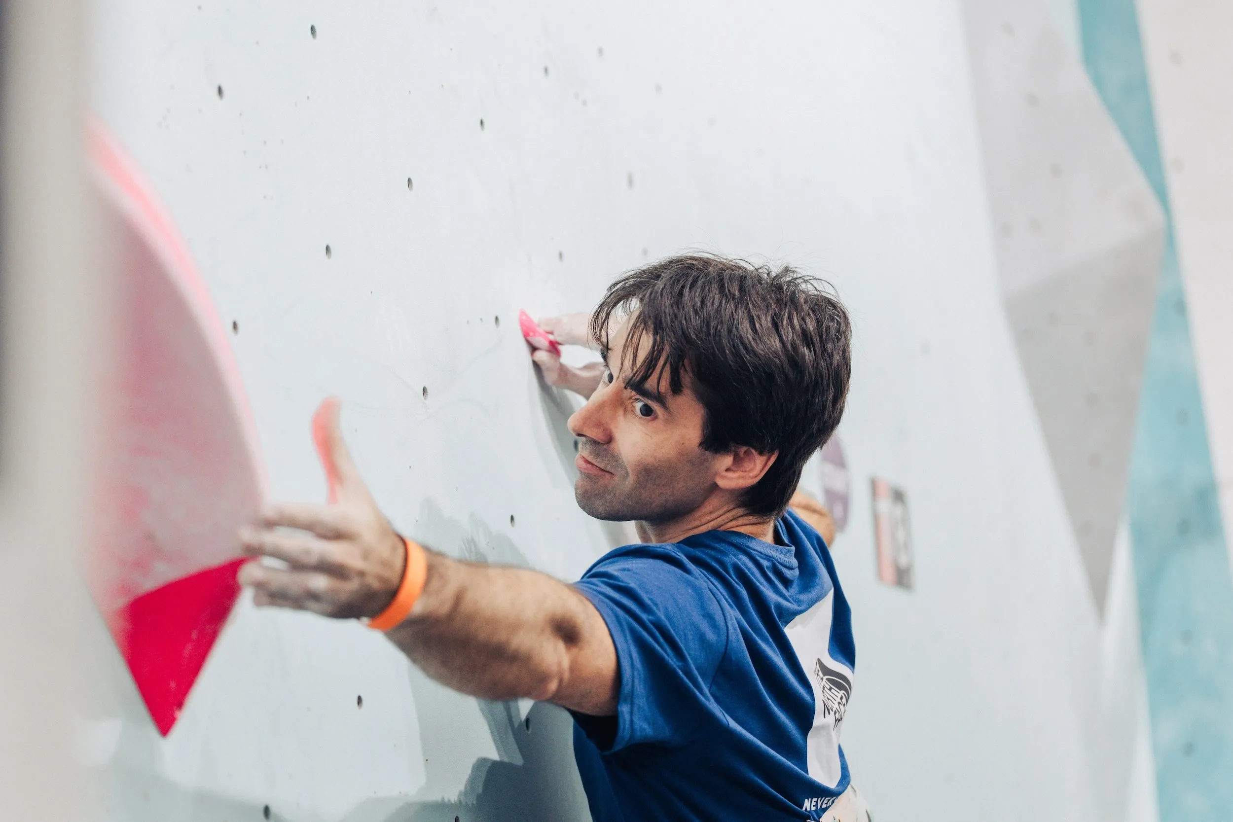 A Squad Games competitor reaching for climbing hold