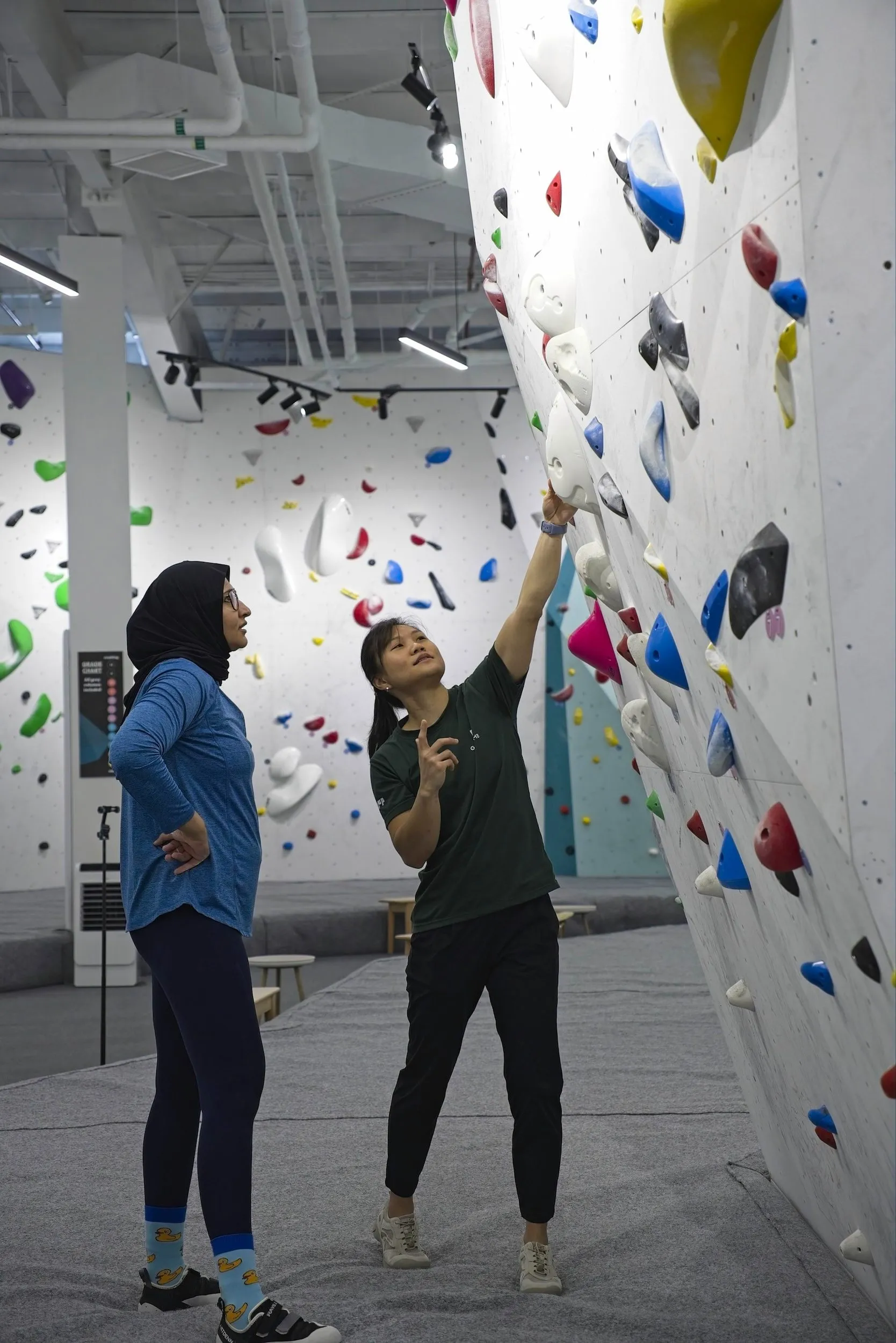 A coach teaching technique to a climber.