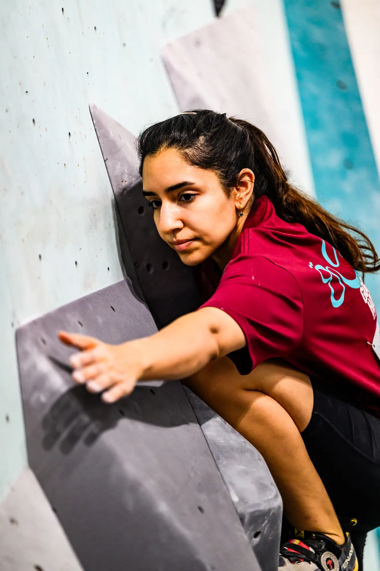 A competitor mid-qualifier, eyes fixed on the next hold