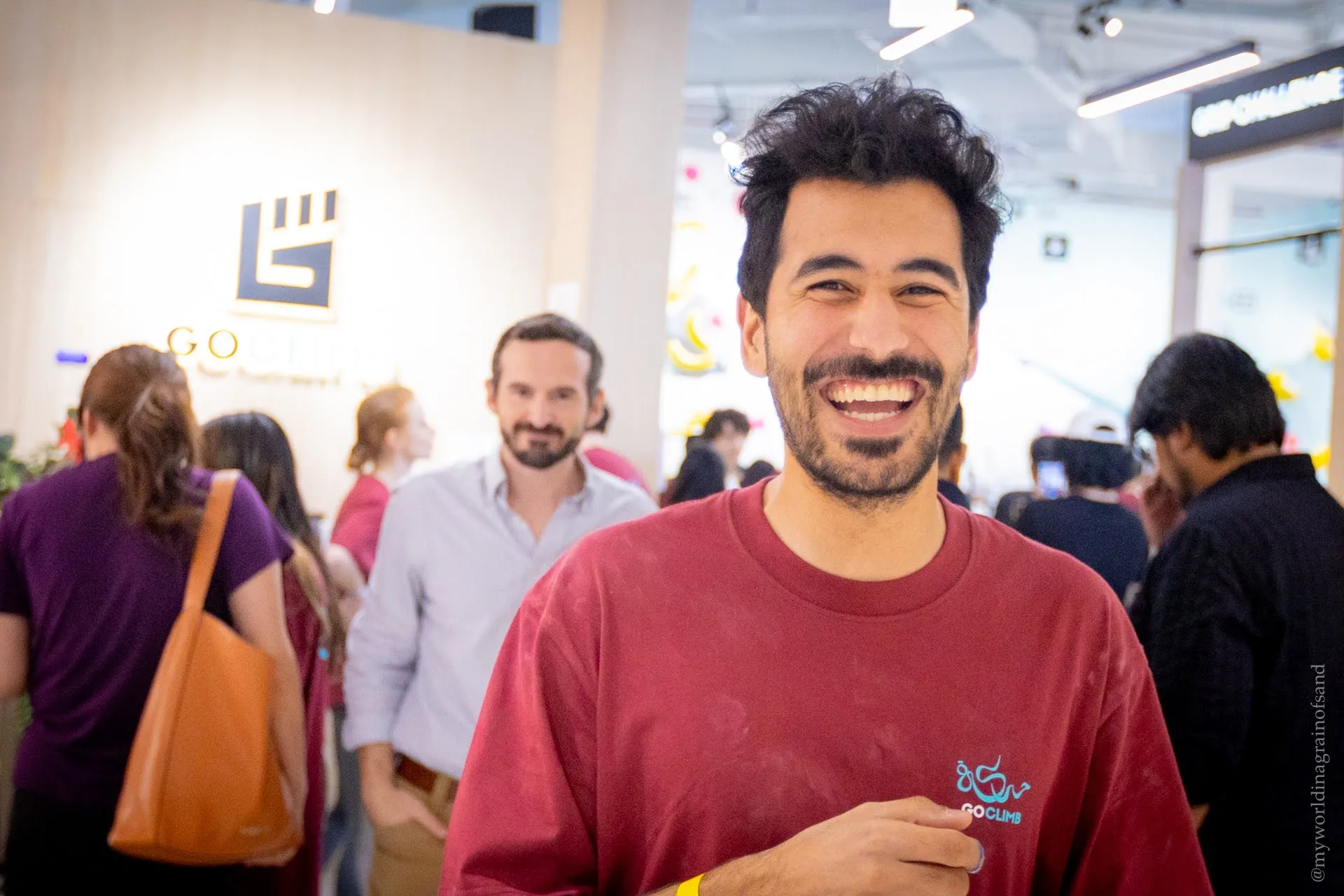 A climber in a GoClimb shirt grinning at the camera between sessions