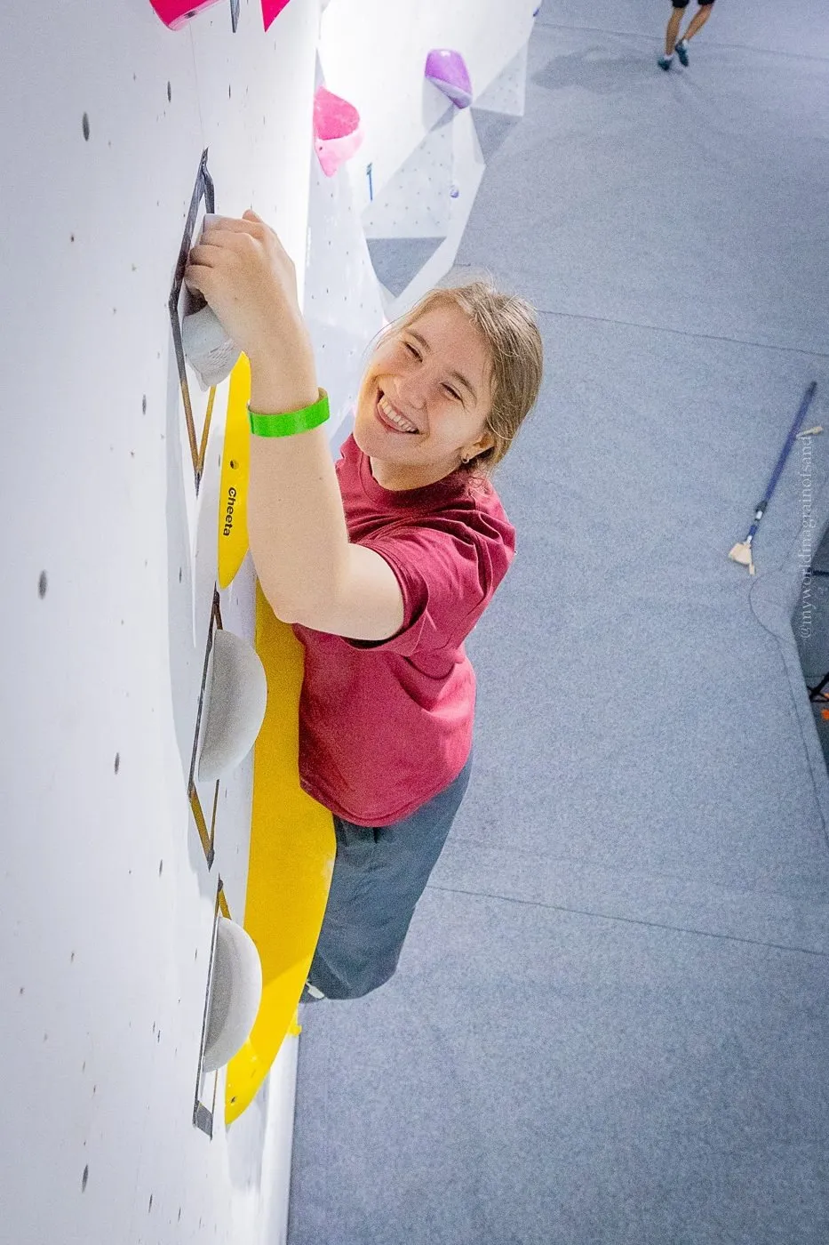 A first-time climber smiling up from the wall